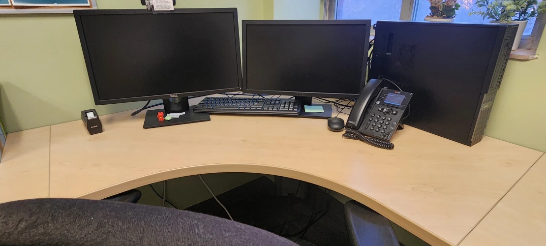 work space in the HUB with two monitors and an office chair facing a window