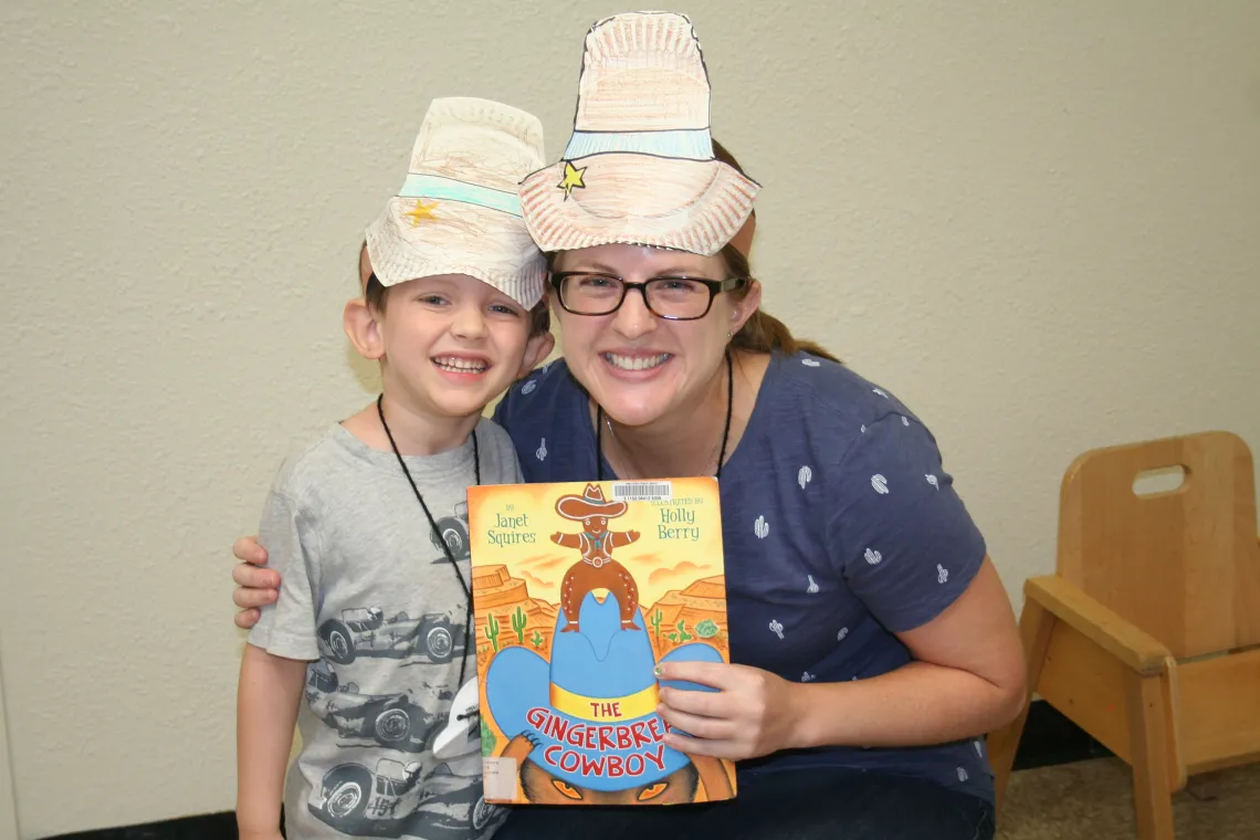 PhD student with camper holding book PhD student with camper holding book