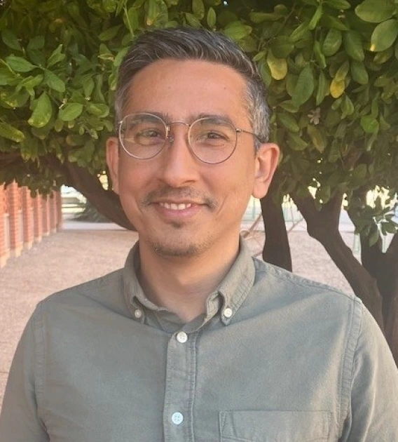 Image of a man wearing glasses smiling and looking at camera
