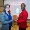 Image of two women holding an award between them and smiling at the camera